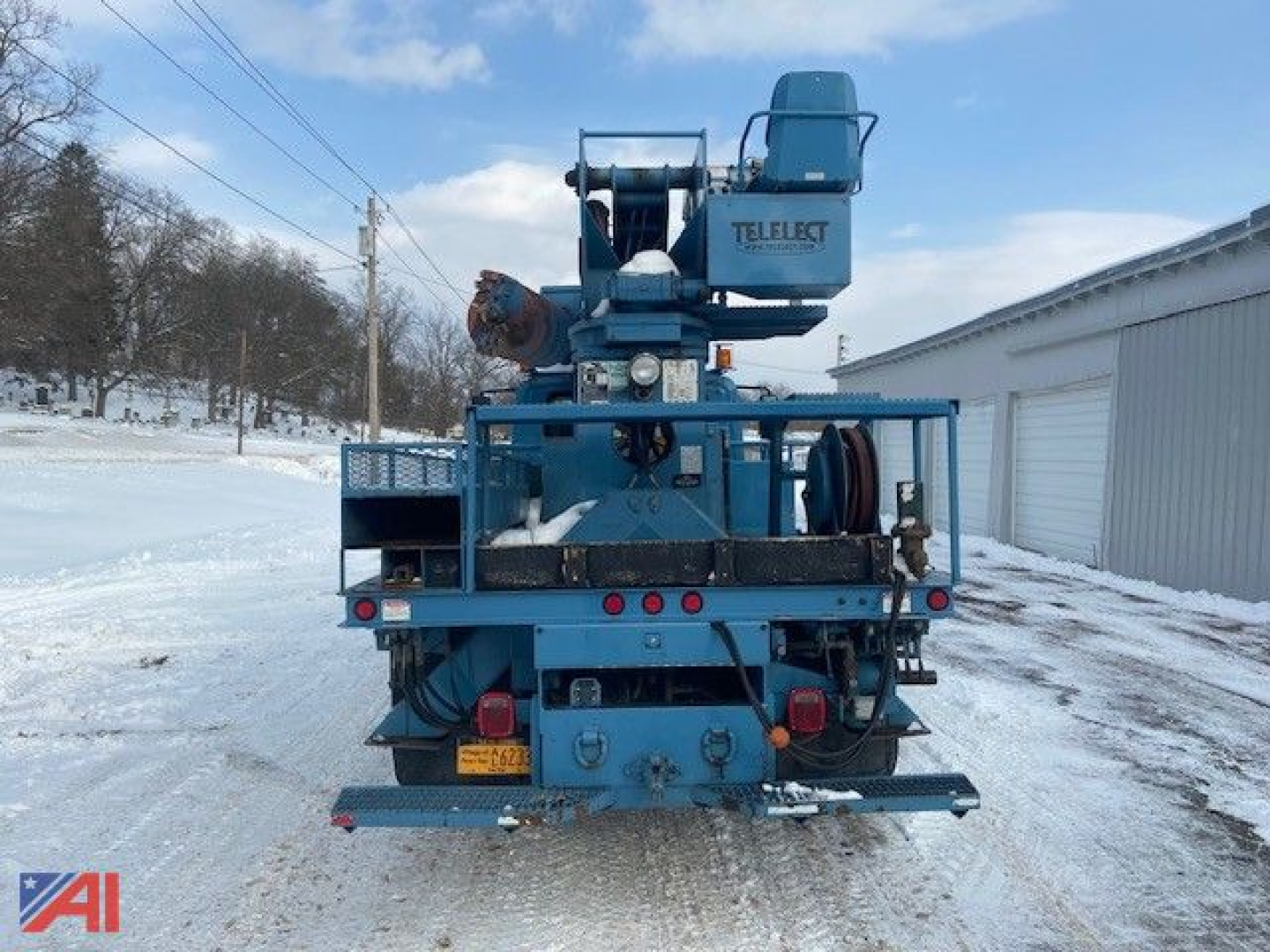 Back view of 2002 International DuraStar 4300 Digger truck with mounted crane and TELEFEST unit, on snow-covered lot.