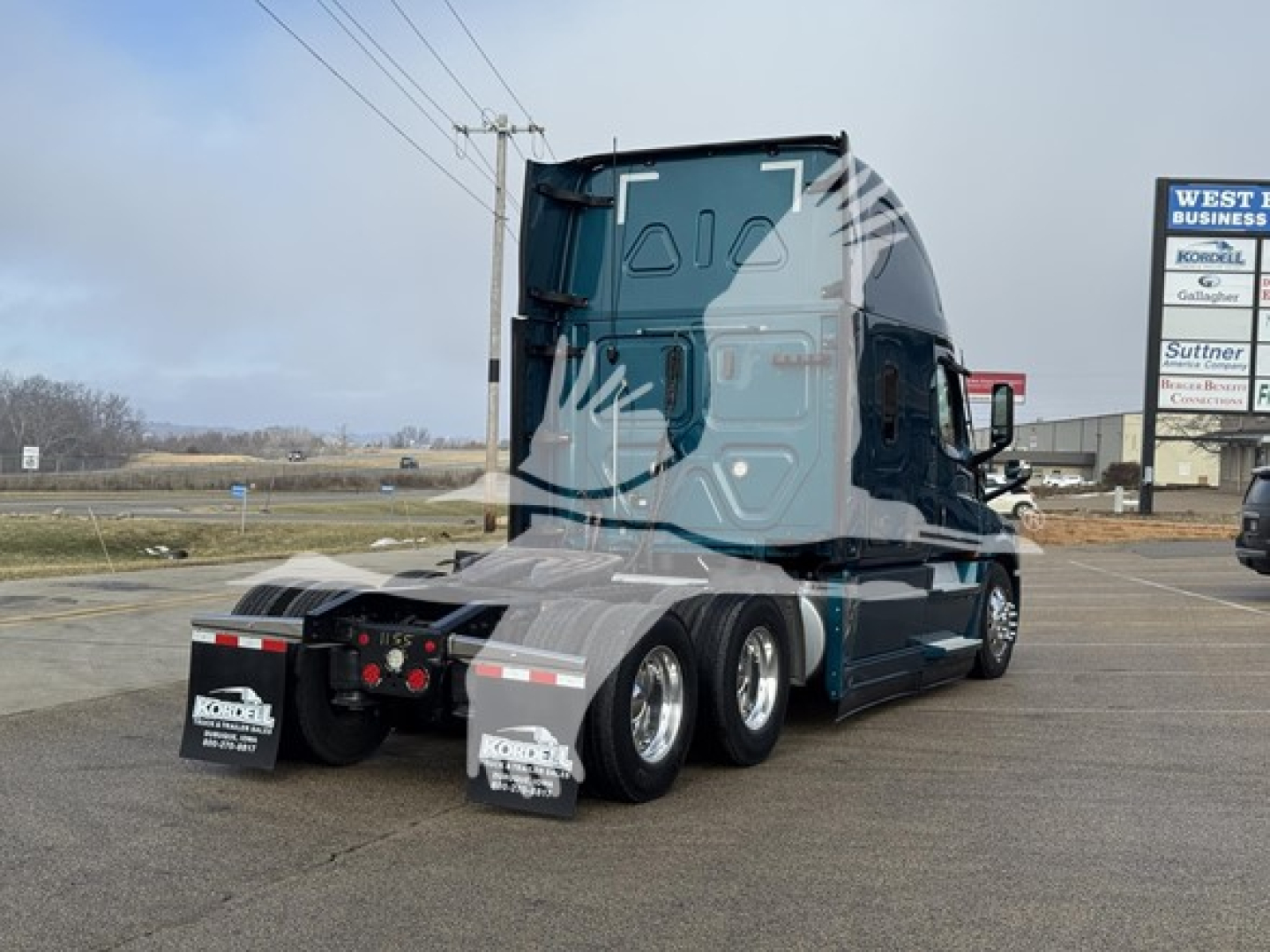 Freightliner Cascadia 126 tractor rear and sleeper cab showing tandem rear wheels and mud flaps.