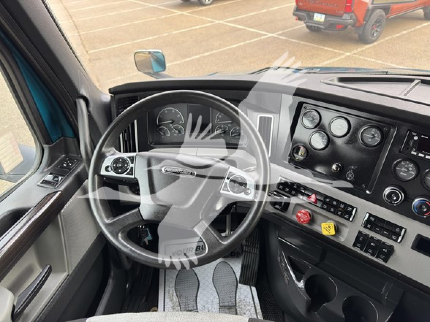Cab interior of a Freightliner Cascadia showing steering wheel and dashboard gauges