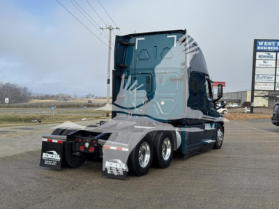 Freightliner Cascadia 126 tractor rear and sleeper cab showing tandem rear wheels and mud flaps.