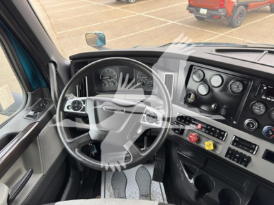 Cab interior of a Freightliner Cascadia showing steering wheel and dashboard gauges