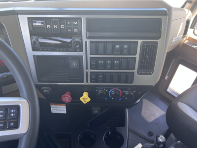 Dashboard of a 2026 Mack GR64F dump truck showing the center console with gear indicator, various control switches, ignition area, and climate controls.