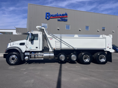 Truck side view of a 2026 Mack GR64F dump truck showing long aluminum dump bed and multiple rear axles.
