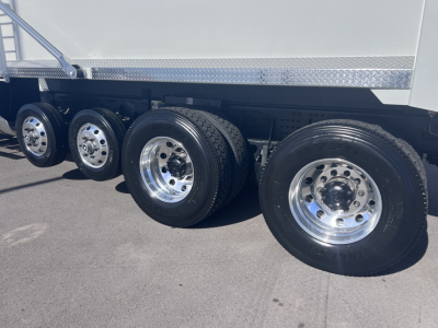 Mack GR64F dump truck rear wheels and tandem axle with polished chrome rims and dual rear tires.