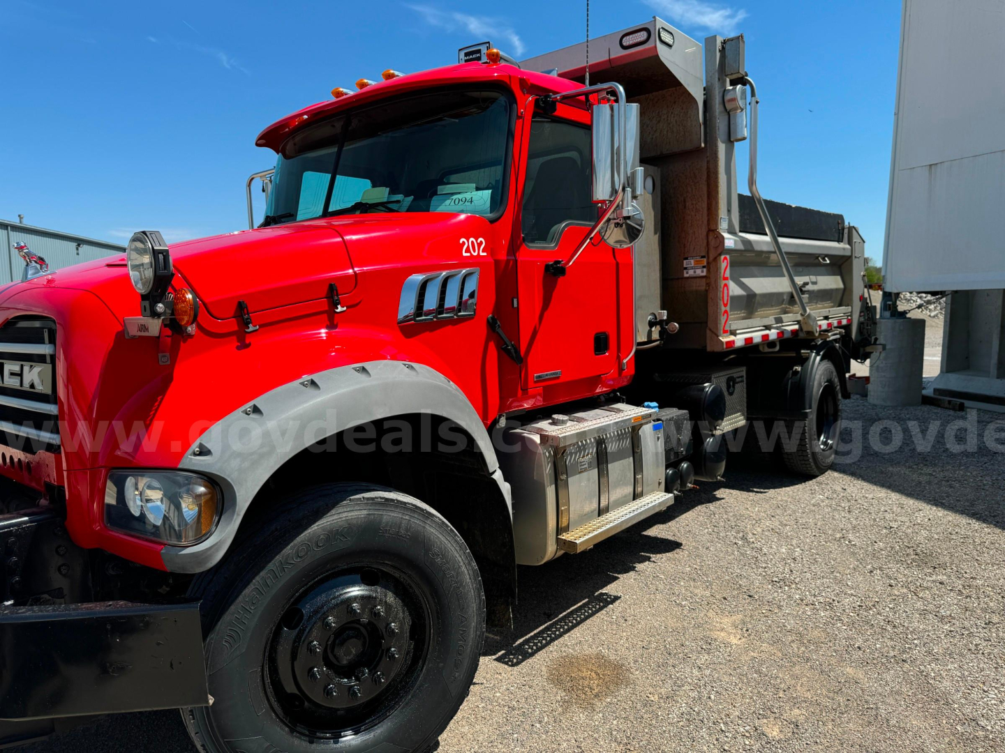 Red 2019 Mack Granite dump truck with white fenders and a plow, side view showing cab and dump bed, stock number 603-6632, VIN 1M2GR2AC9KM001132