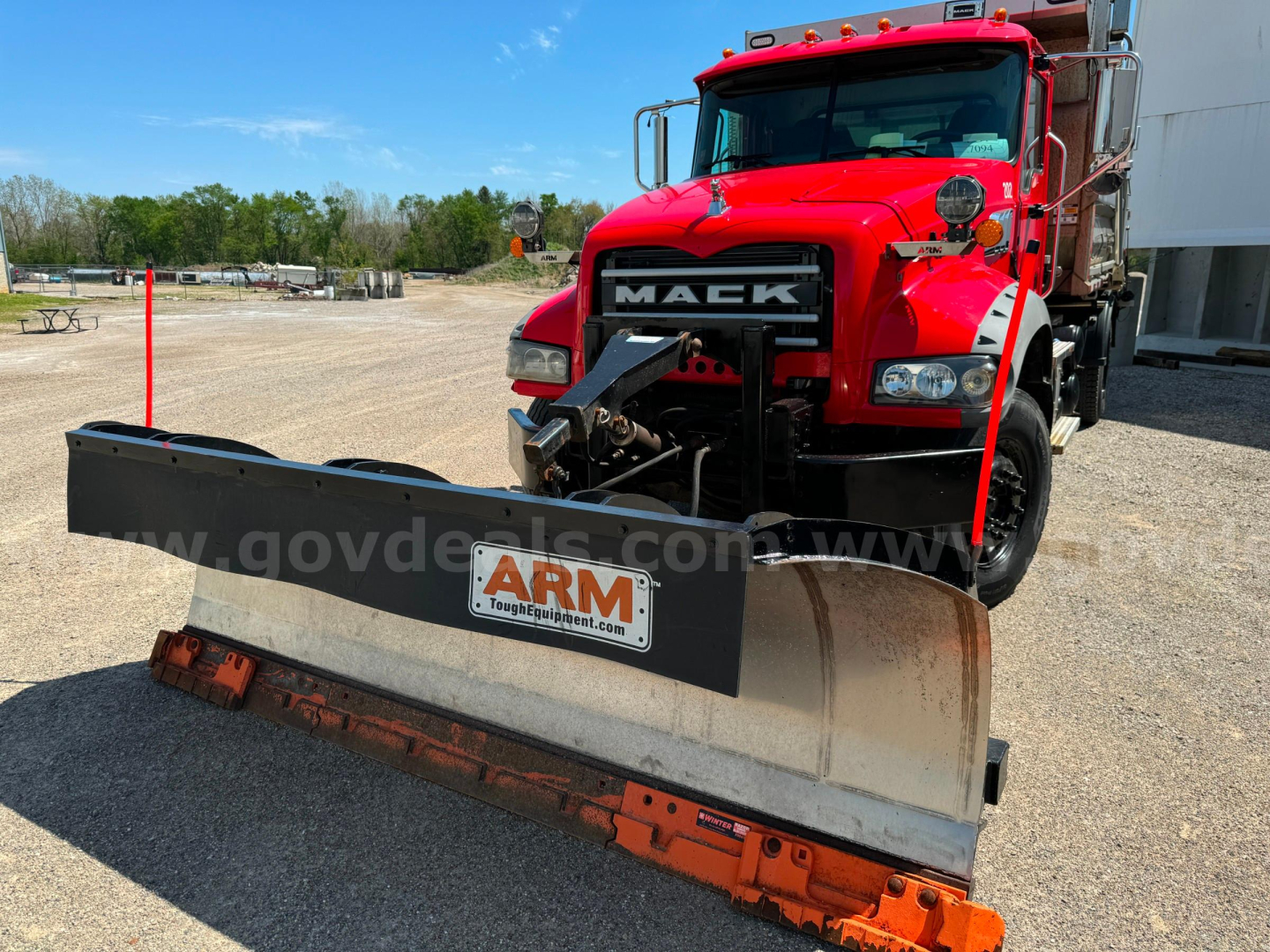 Mack Granite plow truck showing front snow plow and red cab with Mack emblem and ARM plow plate.