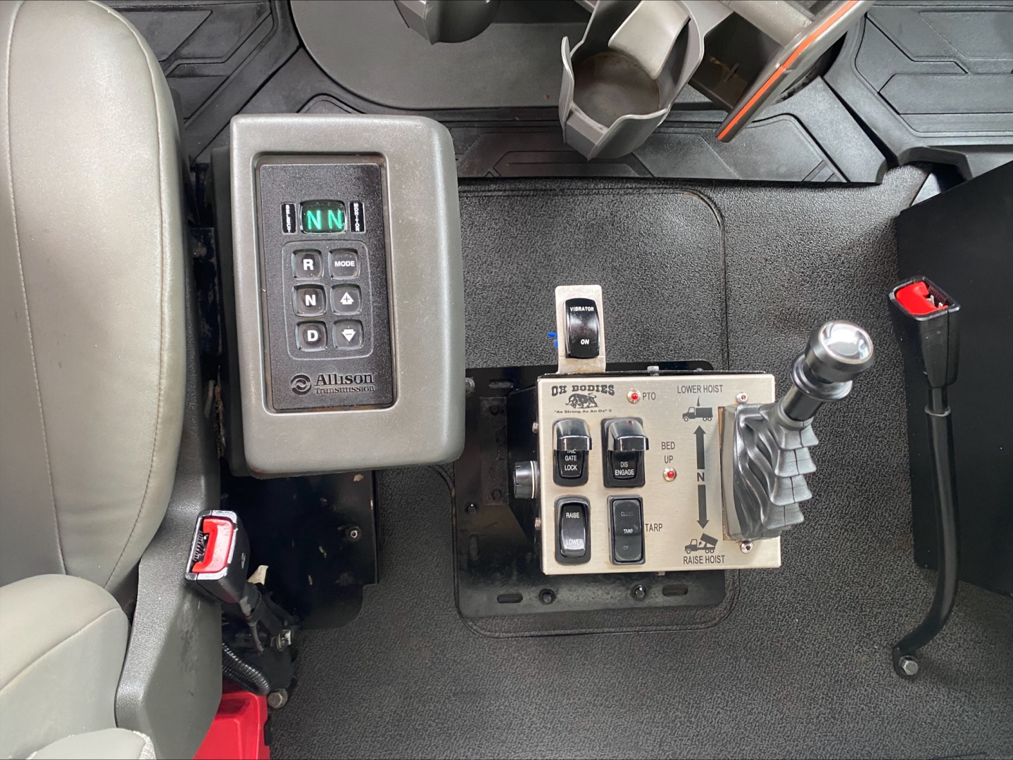 Cab interior showing gear selector panel and joystick-style control levers in a Volvo VHD dump truck.