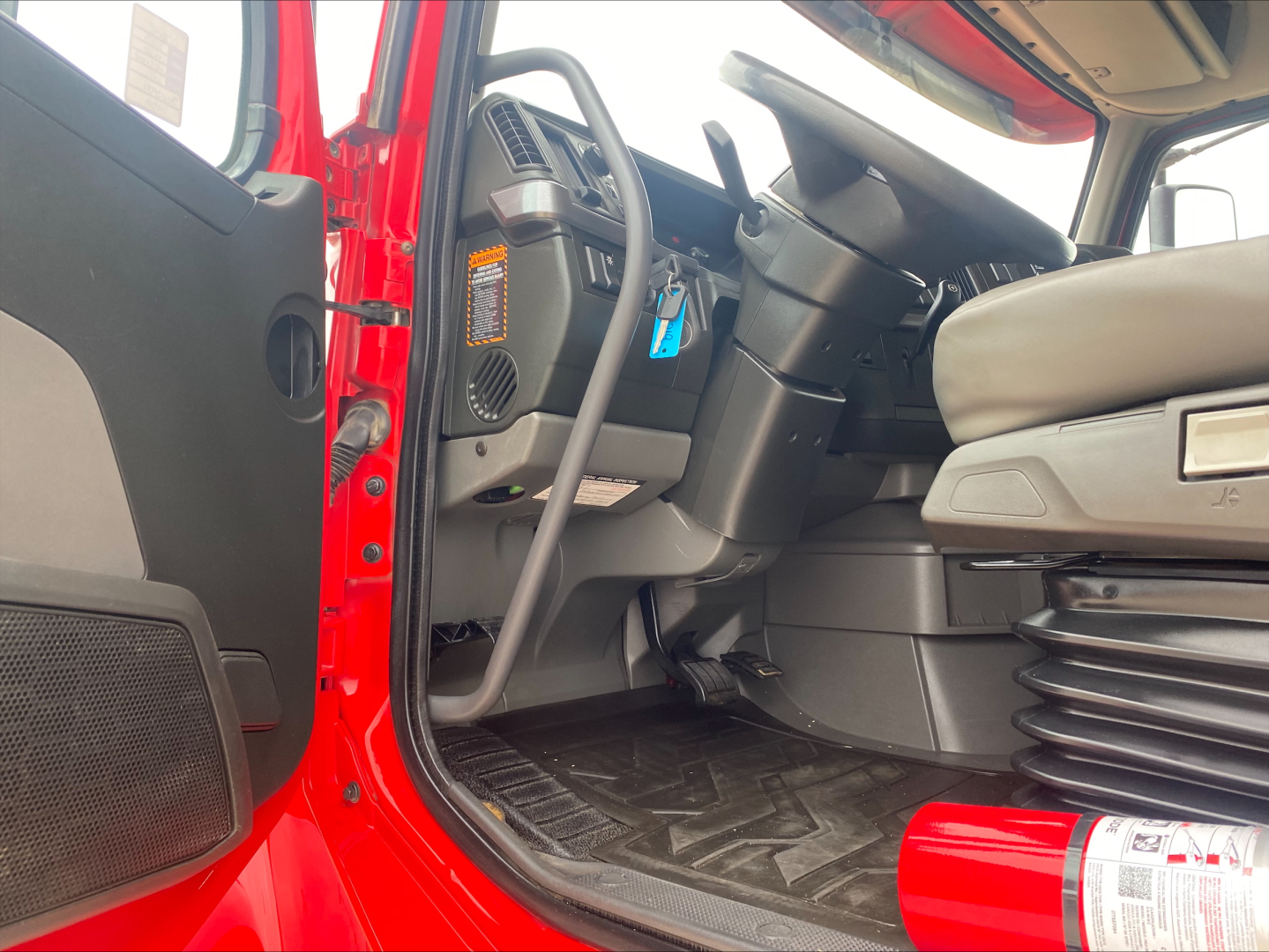 Volvo VHD84F200 cab interior view showing driver seat and dashboard with steering wheel and pedals.