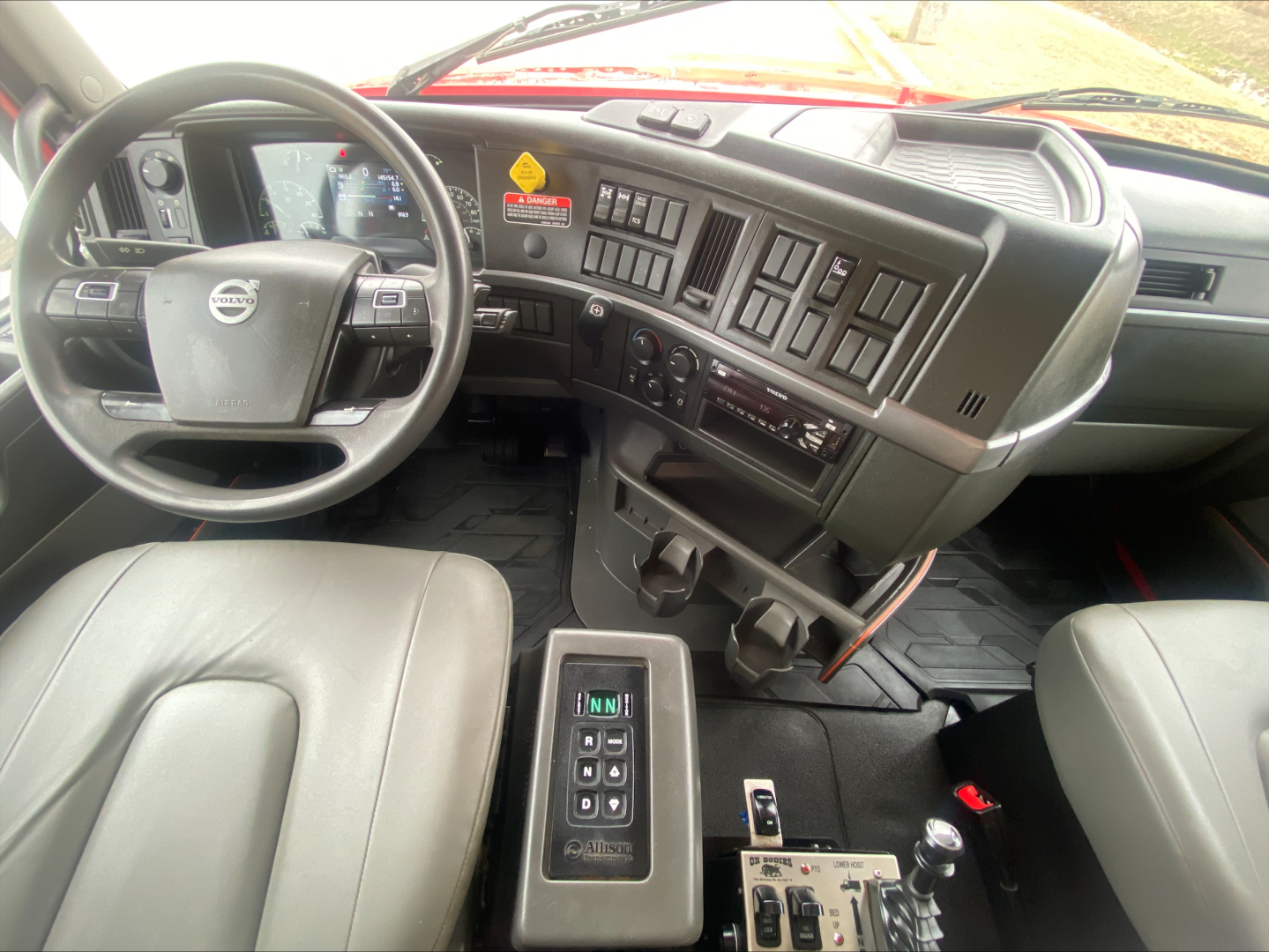 Volvo VHD84F200 truck dashboard interior with steering wheel, array of control panels, and gear shifter in center console.