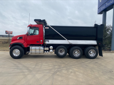 Dump truck in red cab with black dump bed, side view showing chrome fuel tanks and dual rear axles.