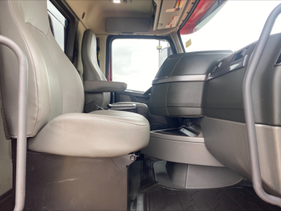 Cab interior of a Volvo VHD truck showing driver seat, passenger seat, and dashboard from a low angle.