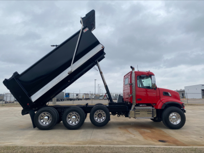 Truck chassis with raised dump bed on a red Volvo VHD84F200 dump truck showing side profile and hydraulic lifting mechanism.