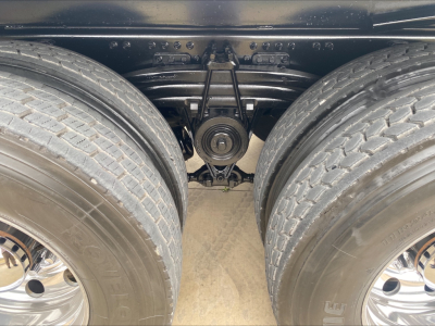 Rear view of a Volvo VHD84F200 truck chassis showing tandem rear axles and leaf spring suspension, with dual tires and visible undercarriage components.