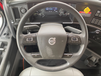 Volvo steering wheel and dashboard inside cab showing Volvo logo on steering wheel and instrument cluster.