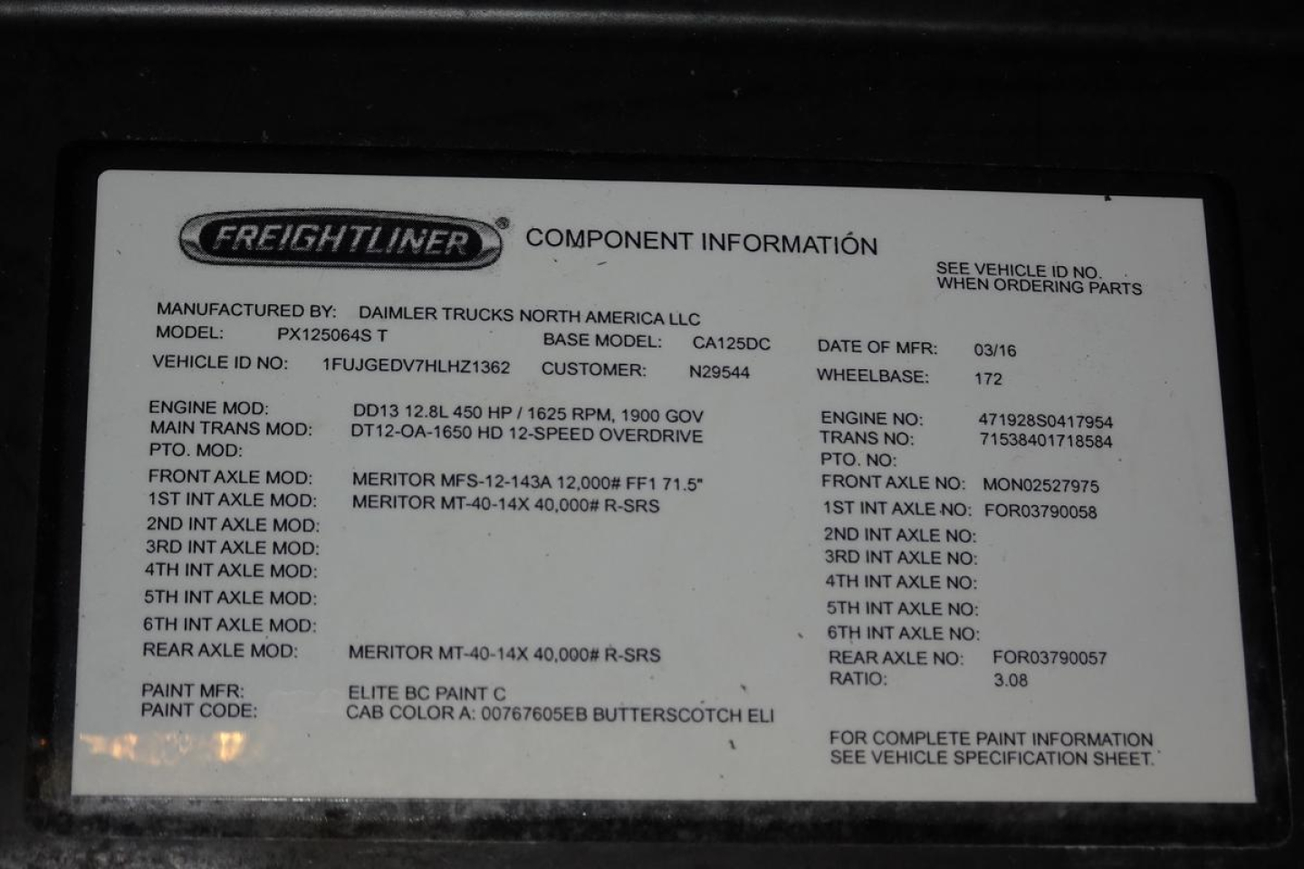 Freightliner badge plate with component information on a Cascadia 125; shows model, VIN fragment, engine and drivetrain data, paint code, and various service notes.