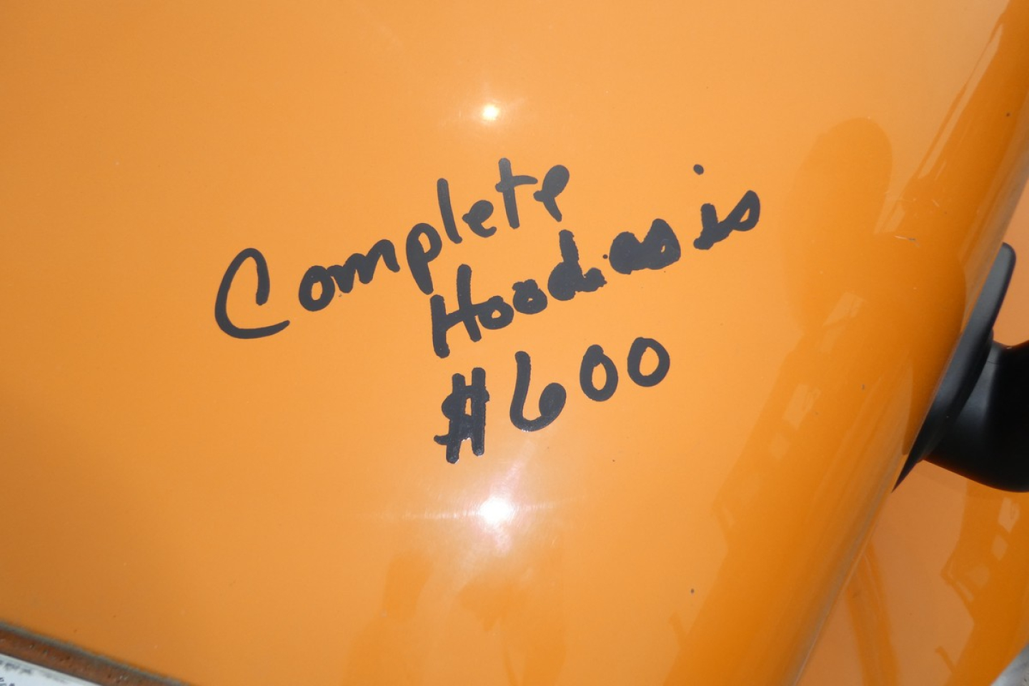 Orange surface with handwritten text reading ‘Complete Hood cost $600’