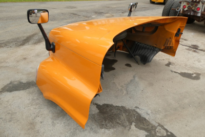 Orange Freightliner Cascadia 125 cab exterior showing left front fender and door mirror