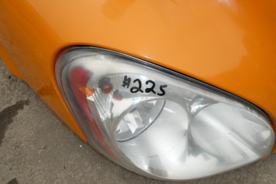 Headlight assembly of a Freightliner Cascadia headlight with '#225' marking on the lens.