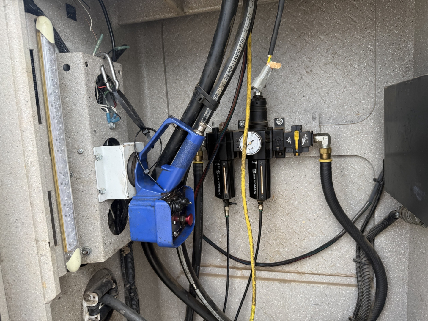 Kenworth T270 service truck engine bay with blue hydraulic pump, hoses, and gauges visible.