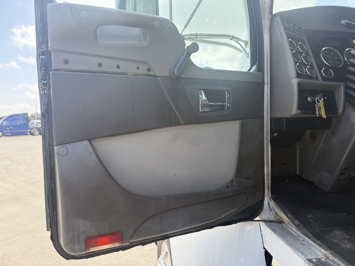 Kenworth T270 dashboard and front door interior view showing passenger door panel and part of steering wheel area.
