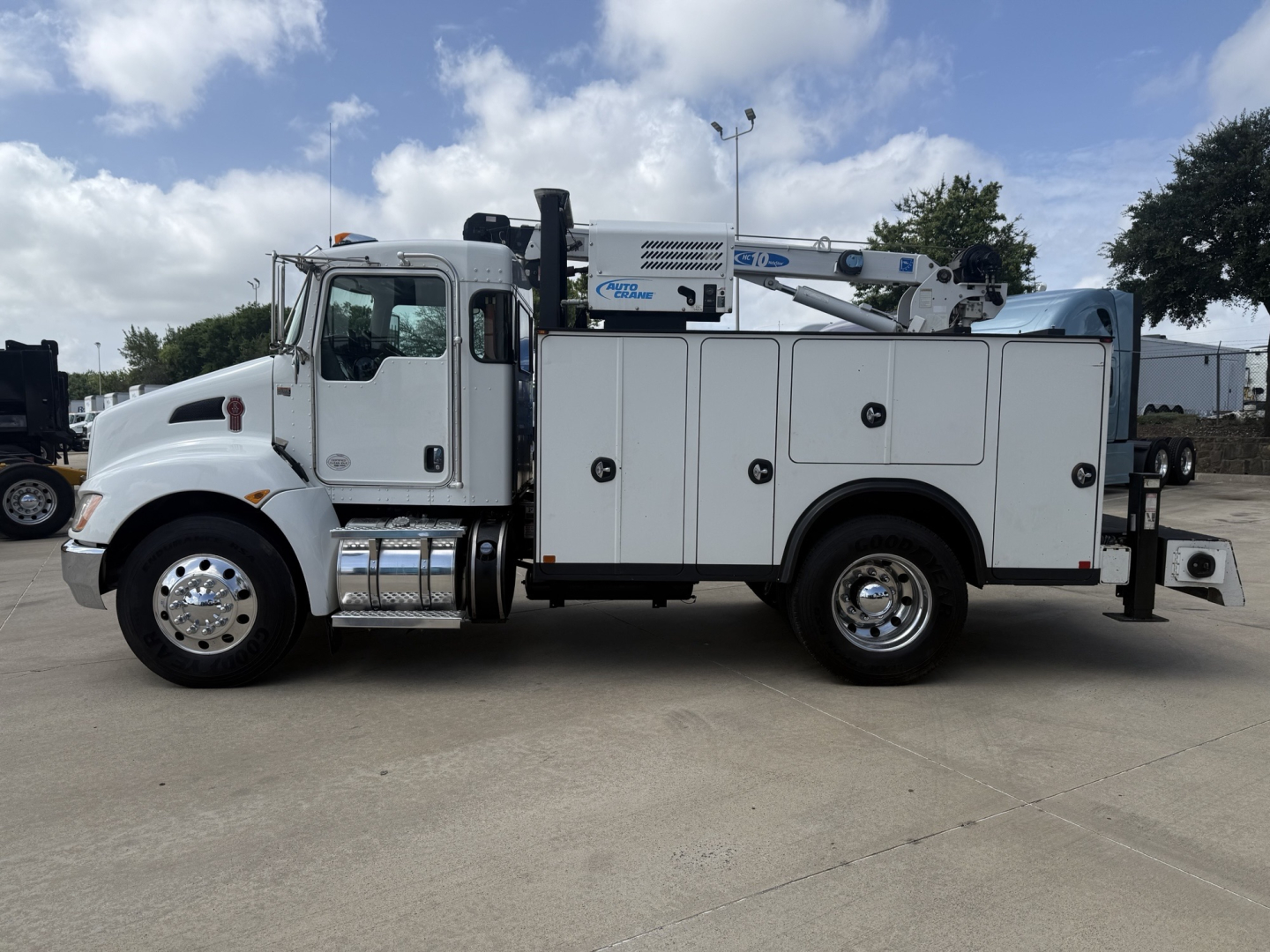 Kenworth T270 service body truck side view showing utility compartments and crane mid-body.