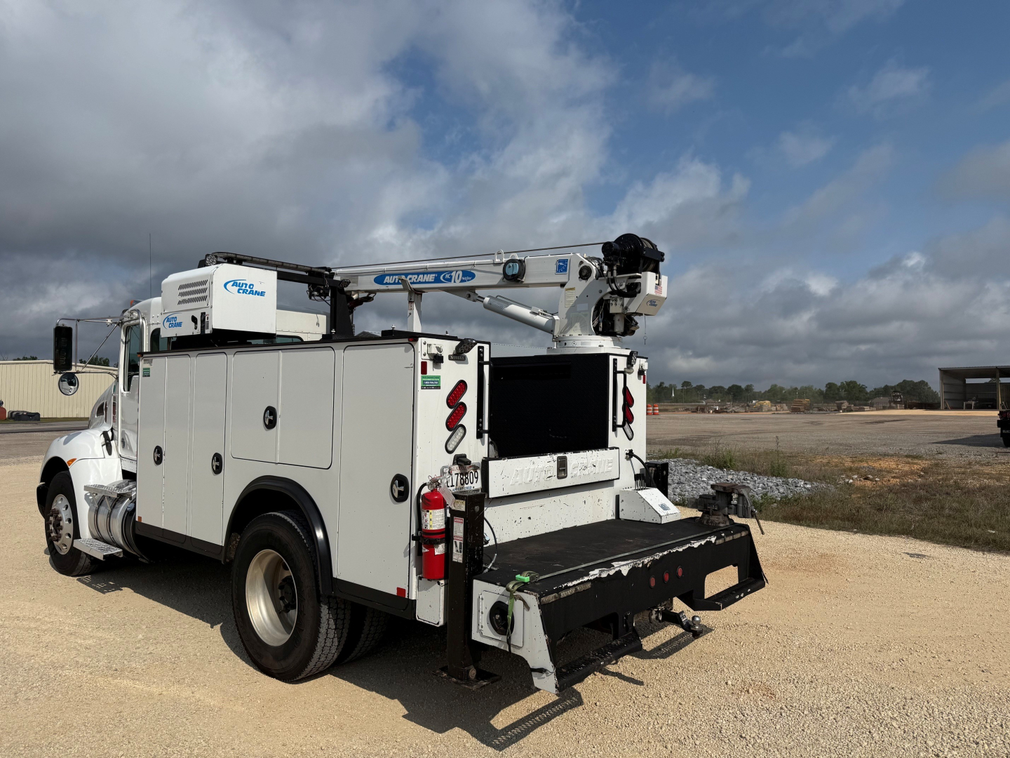 Kenworth T270 service truck with utility body and crane, rear access platform extended, white with compartments and ladder, side view.