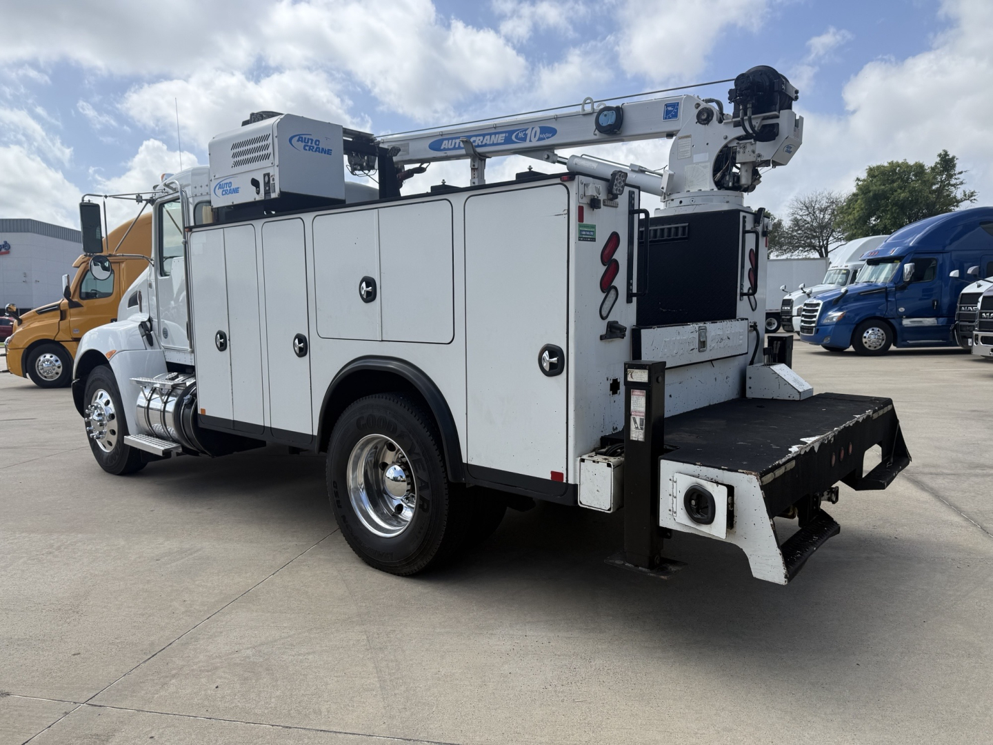 Kenworth T270 service utility truck with crane and storage compartments, side view showing white utility body and rear equipment platform.