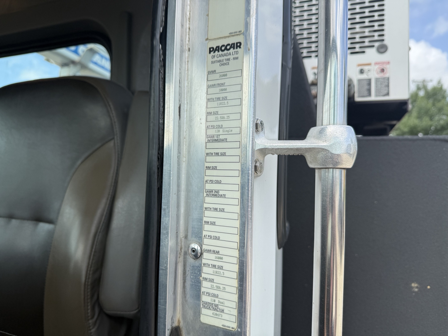 Kenworth T270 service truck cab interior near door frame with vertical placard listing specifications and tire information