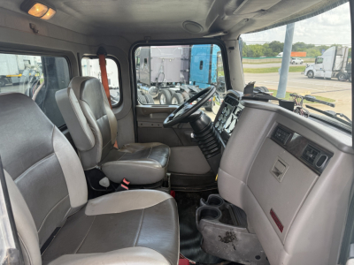 Kenworth T270 cab interior showing driver and passenger seats, dashboard, steering wheel, and center console with cup holders.