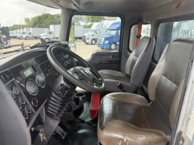 Kenworth T270 cabin interior showing steering wheel and front seats with dashboard and control panels.