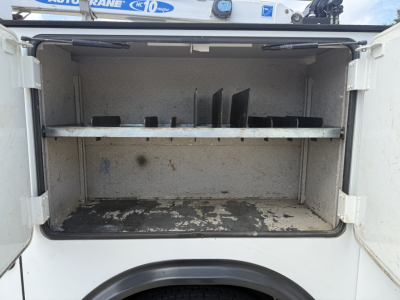 Kenworth T270 service truck rear cargo area with open storage compartment showing bare metal shelves and signs of use.
