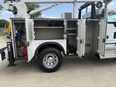 Kenworth T270 service truck side compartments open showing tool storage and hydraulic crane. Side doors exposed with shelving and equipment inside.