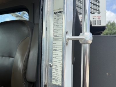 Kenworth T270 service truck cab interior near door frame with vertical placard listing specifications and tire information