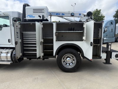 Kenworth T270 utility truck side view with open tool compartments and crane, visible rear wheels, storage shelves and drawers.