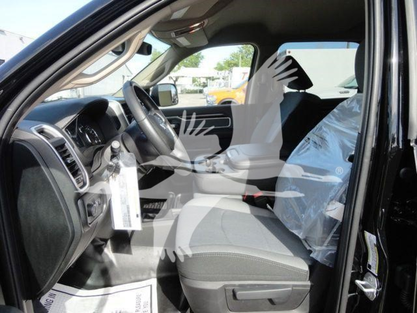 Ram 5500 cab interior showing driver seat and front console with plastic-wrapped passenger seat.