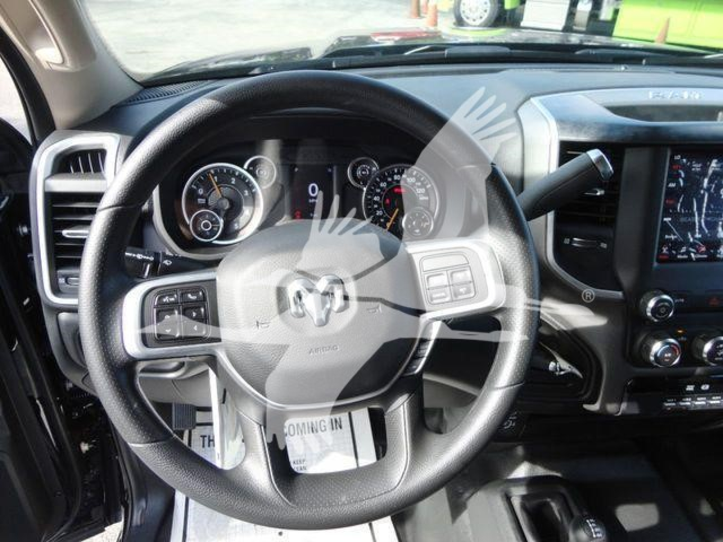 Ram interior showing steering wheel with RAM logo, dashboard gauges, and center touchscreen in a new 2024 Ram 5500 SLT.