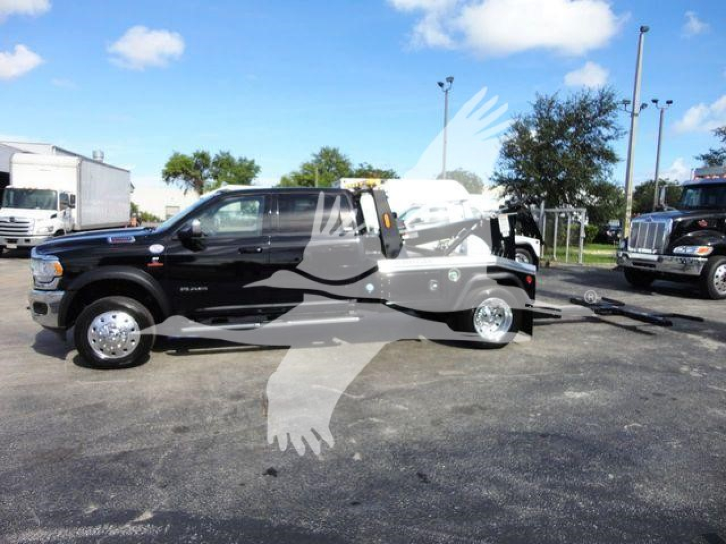 2024 Ram 5500 SLT on dealer lot showing winch equipment and Ram emblem on black crew cab with towing apparatus