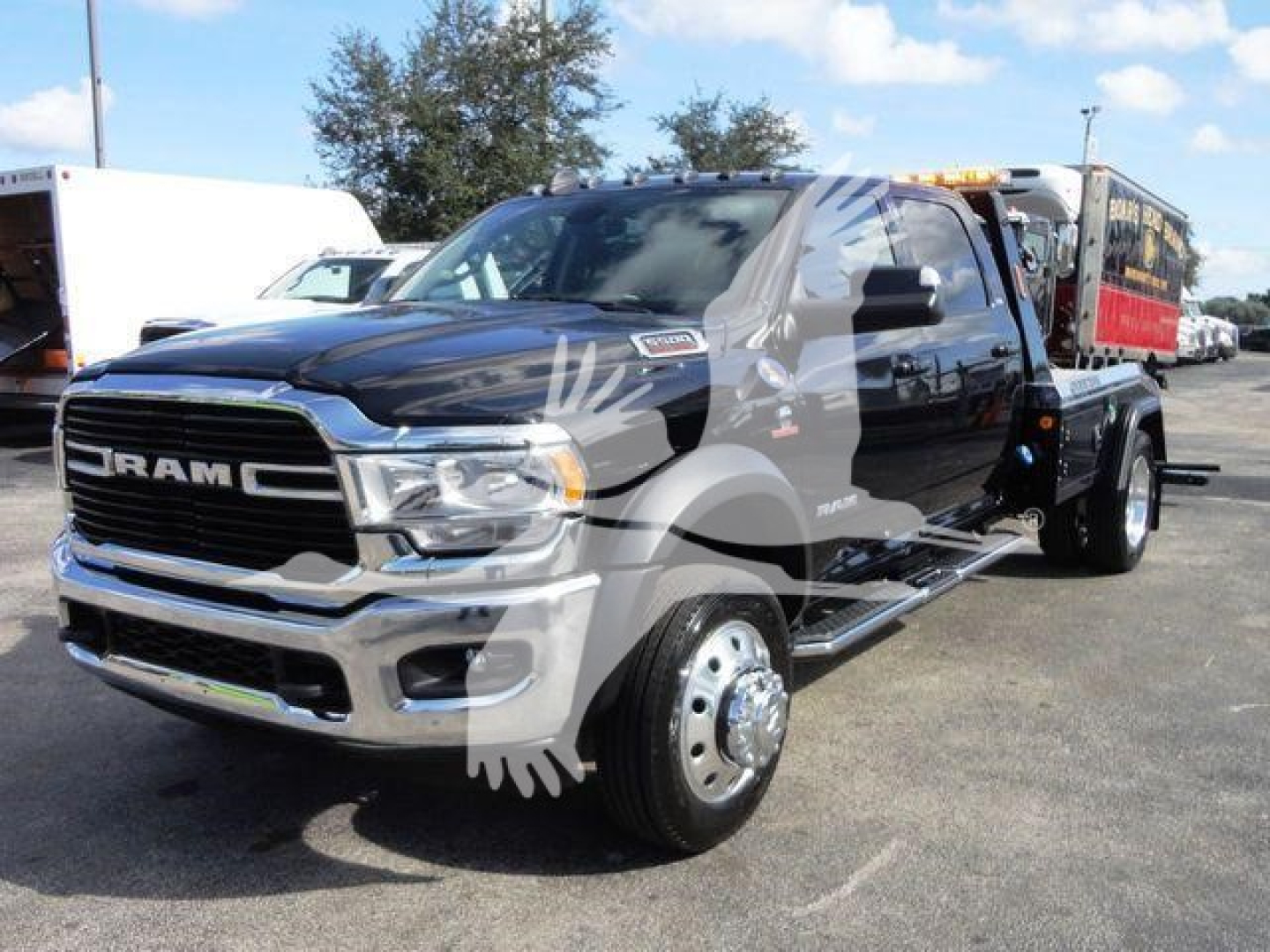 Ram 5500 truck in service bay/front view showing GRILLE RAM emblem, chrome bumper, dual mirrors, large side steps, and heavy-duty wheels.
