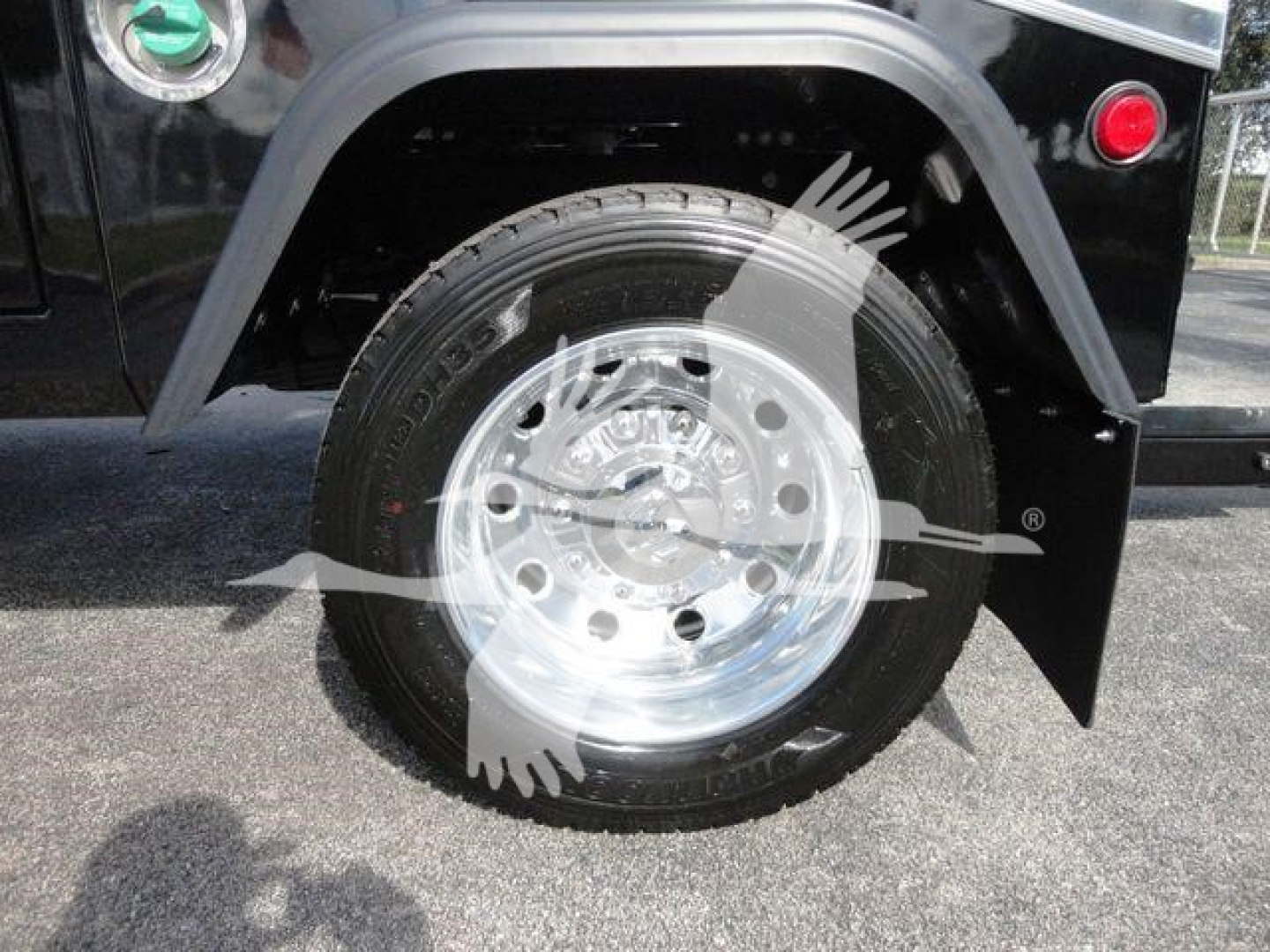 Wheel and tire of a Ram 5500 SLA T truck with chrome rim and black fender, view of front wheel well.