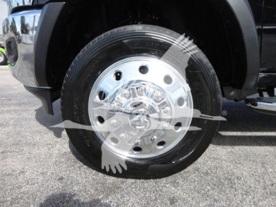 Wheel and tire on a Ram 5500 front axle with polished steel hubcap and dual lug nuts visible in wheel well