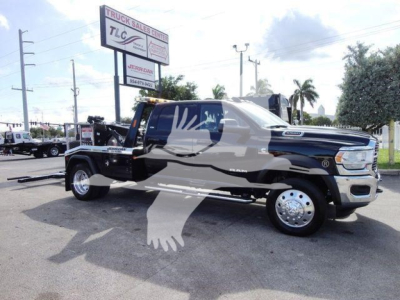 Ram 5500 SLT tow truck chassis with front cab and winch setup visible, side profile, dealership lot in background.