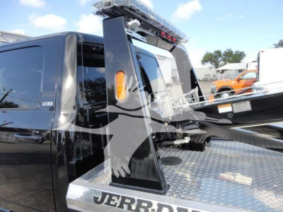 Ram 5500 SLT crew cab truck with a heavy-duty winch system and platform, black exterior, showing winch equipment and diamond plate bed.