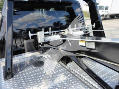 Ram 5500 SLT winch truck bed showing aluminum diamond plate and winch mechanism mounted behind cab.