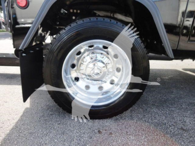 Wheel on Ram 5500 truck with polished aluminum rim and black tire, part of a winch-equipped body panel visible.