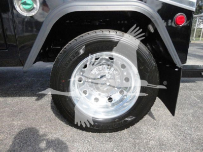 Wheel and tire of a Ram 5500 SLA T truck with chrome rim and black fender, view of front wheel well.