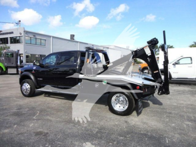 Ram 5500 Tradesman/Tow ready pickup with a mounted winch and crane arm in a dealership lot, side view.