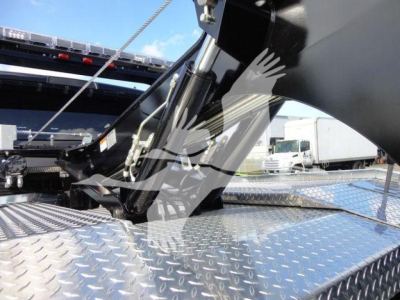 Ram 5500 winch-equipped truck bed showing hydraulic winch components and diamond plate surface with metal framework.