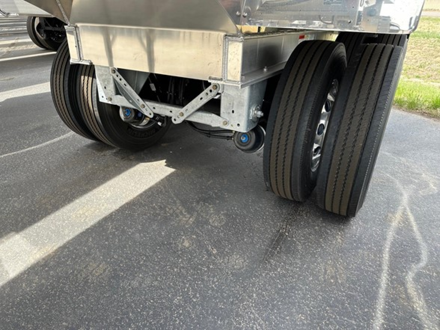Mac Macsimiser trailer showing dual rear axles with large tires and metal suspension components.