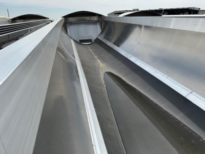 Dump trailer interior showing reinforced steel wells and center trough for material flow inside upper deck.