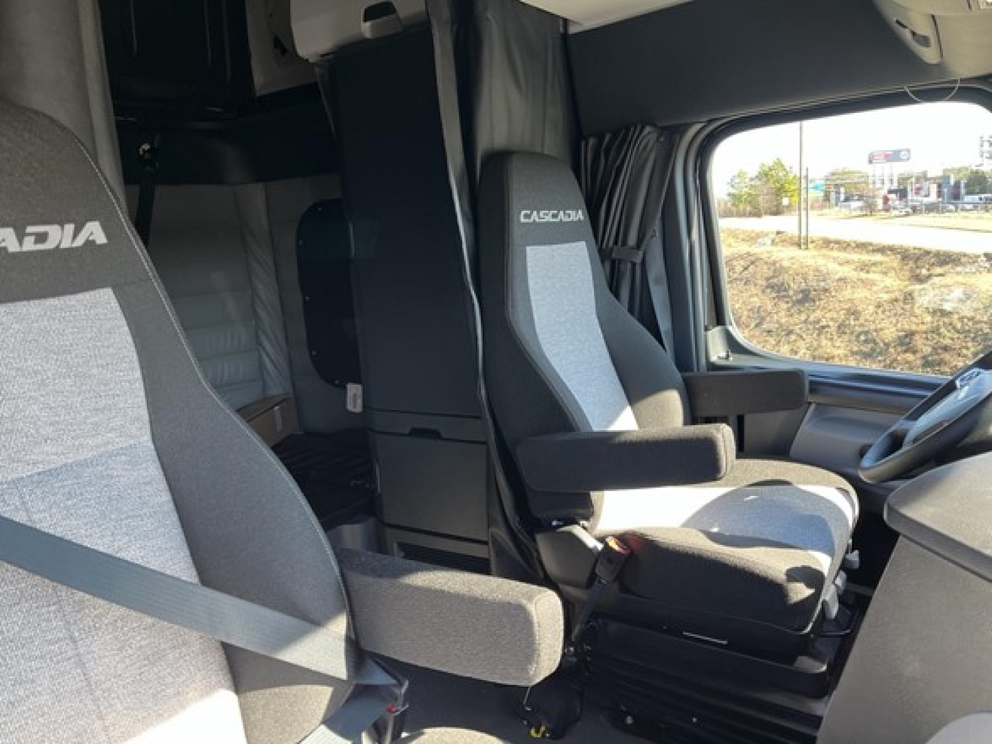 Freightliner Cascadia 126 cab interior view showing driver seat with Cascadia branding and a secondary seat in front area